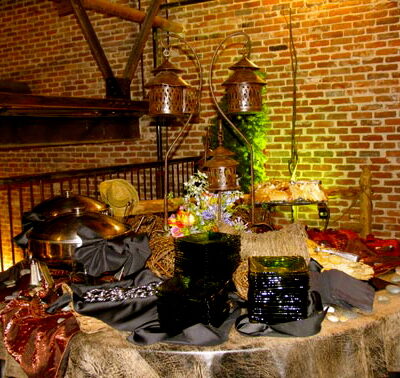 Round buffet display with bronze lanterns and black-and-gold linens