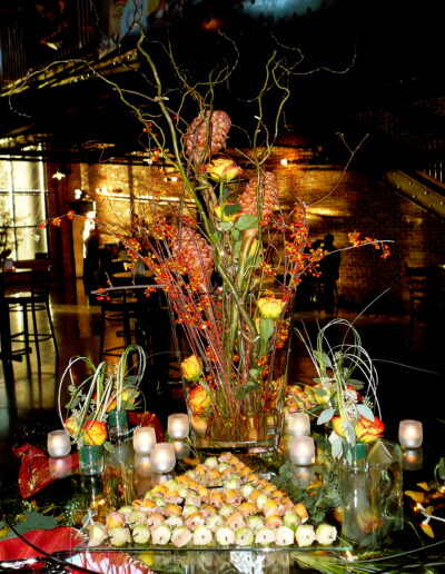 Tall autumn floral arrangement with yellow roses, berries, and branches