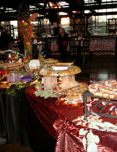 Appetizer buffet with red linens, autumn florals, and trays of crostini