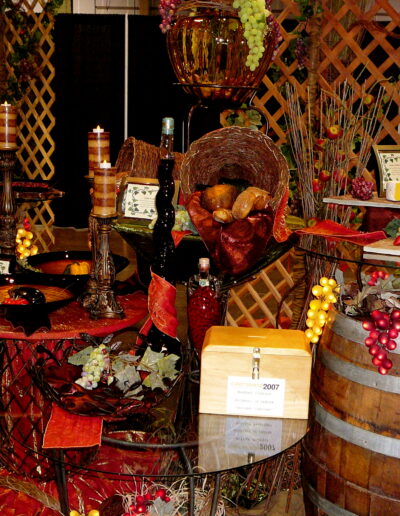 Tuscan-themed cheese display with wine barrels, grapes, candles, and lattice panels